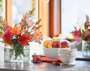 Home kitchen table setting with fruit and flowers.