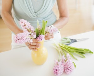Senior woman arranging flowers in vase